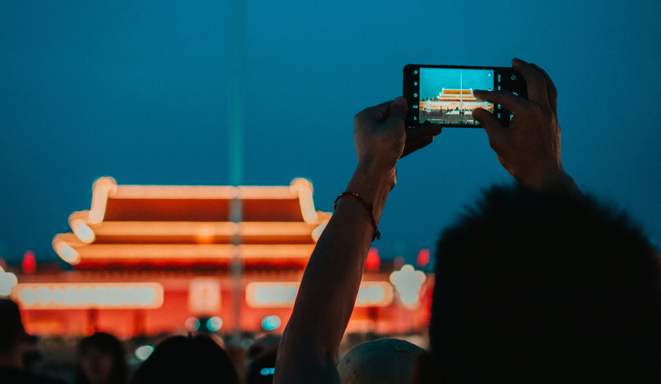 Person photographs the Mausoleum of Mao Zedong in Beijing with a smartphone.