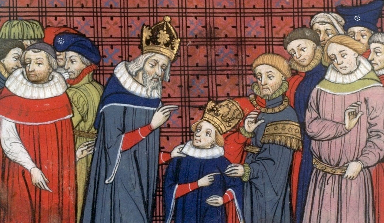 Medieval illustration of Charlemagne, wearing a gold crown and blue robes, instructing his crowned son Louis the Pious before courtiers.