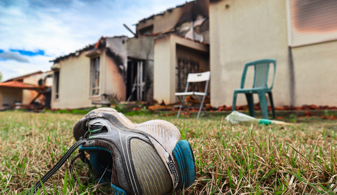 A child’s shoe on grass outside a burned house in Kibbutz Be’eri, Israel.